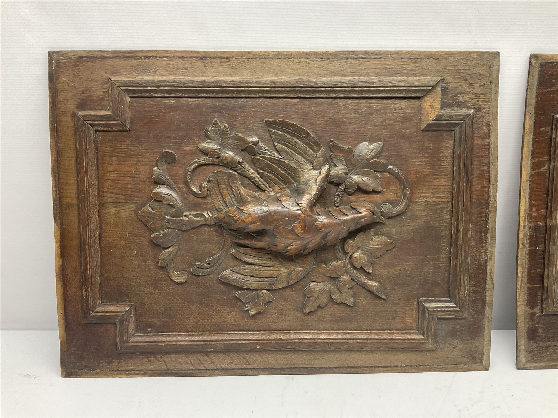Pair of oak furniture door panels, carved in relief with a fox to one and a hound to the other, together with a pair of smaller oak panels, carved in relief with a hare to one and a grouse to the other, doors W63.cm x H62cm, panels W43cm x H60cm
