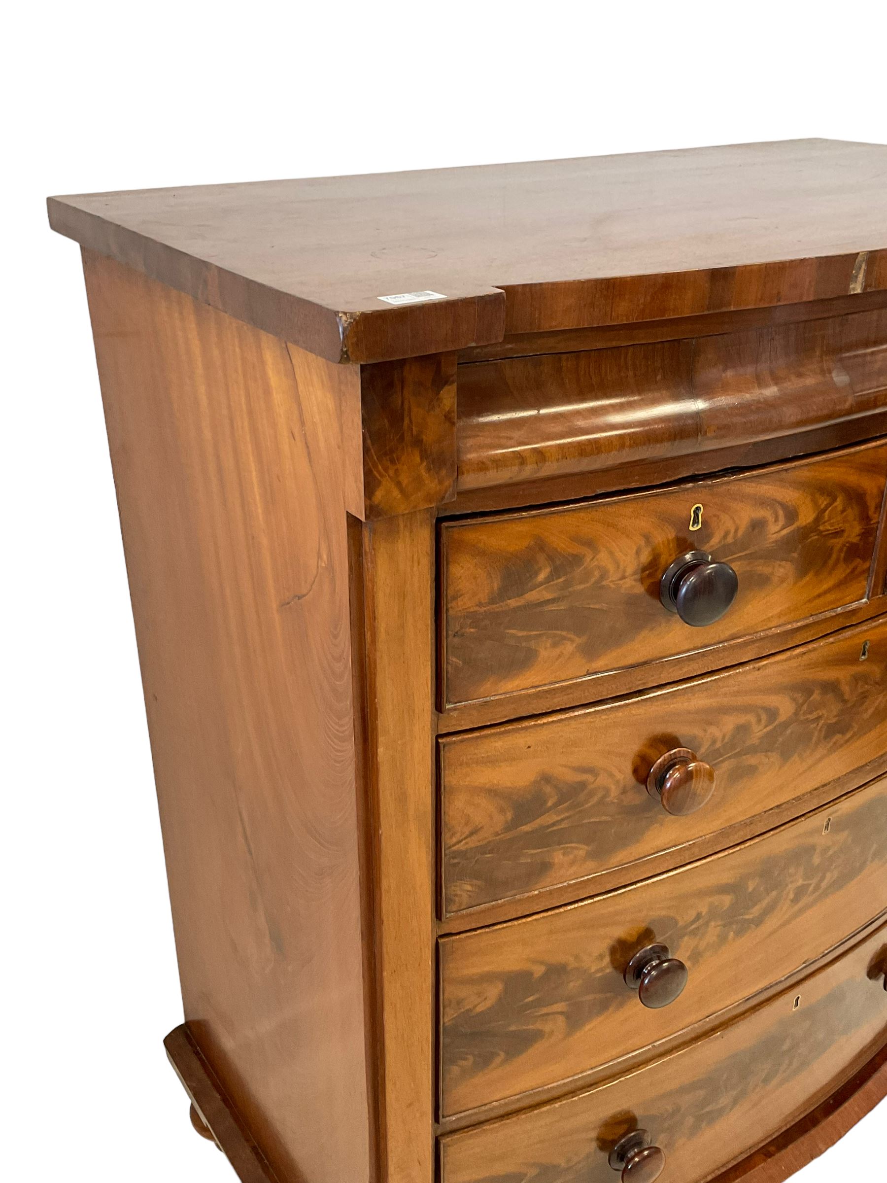 Late 19th century mahogany bow-front chest, fitted with banded cushion drawer with secret catch, above two short over three long graduating drawers, each cock-beaded with turned handles, lower moulded edge over turned feet