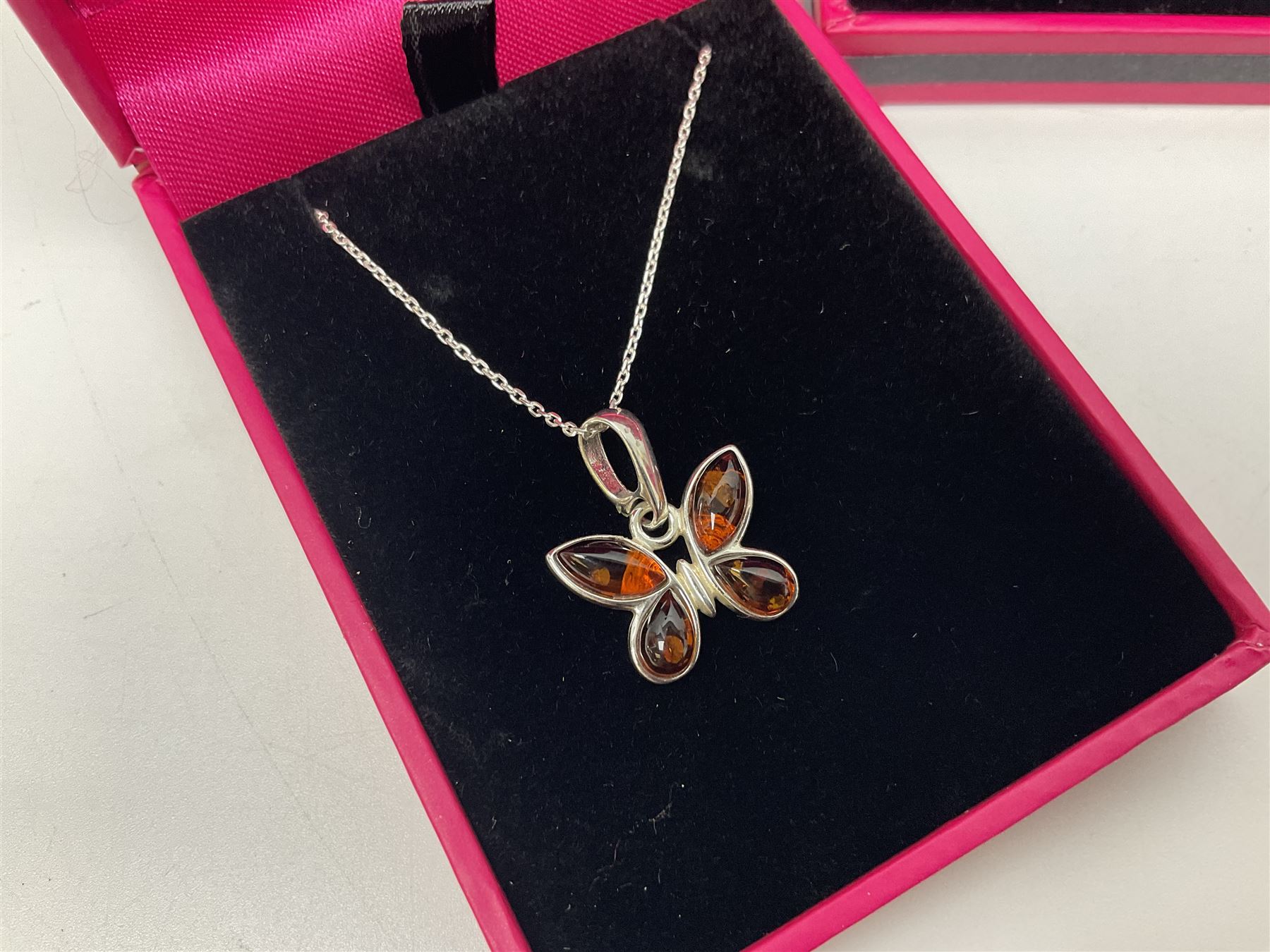 Six silver Baltic amber pendant necklaces, including dinosaur and butterfly designs, all stamped 925 