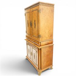 Early 20th century Art Deco burr maple mirrored drinks cabinet, rectangular top with gilted cornice, twin cabinet doors with gilt escutcheons, enclosing a mirrored interior with shelves behind the doors, marble base to the top section above two short drawers over a marble inset slide, the lower cabinet with cabinet doors flanked by pilasters, raised on gilted bracket feet 