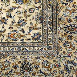 Central Persian Ardakan hand-knotted carpet, ivory field finely decorated with a symmetrical lattice of scrolling vines palmettes and flowering sprays arranged around a delicate central medallion enclosed by a pale border of stylized floral and vine ornament between multiple guard stripes with cotton fringe ends 