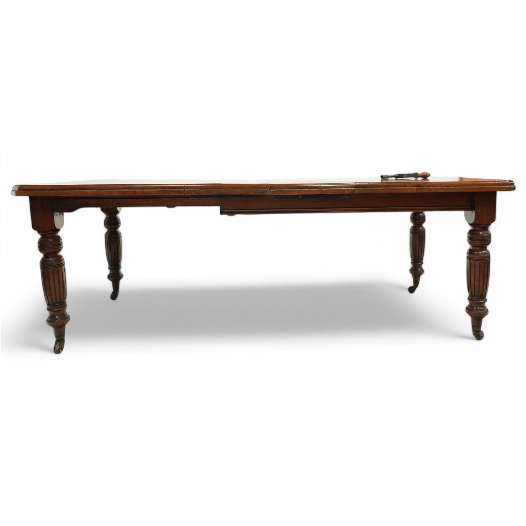 Late Victorian mahogany extending dining table with two leaves, moulded chamfered edge above, turned and reeded legs and ceramic castors, winding handle included, 205cm extended, 132cm closed, 102cm wide, 73cm high