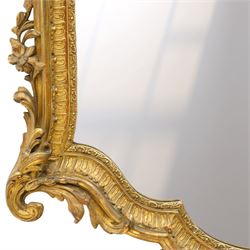 Victorian giltwood and gesso framed ornate wall mirror, the protruding cartouche pediment decorated with extending scrolls of acanthi and flower heads, with scrolled foliage corners flanking a carved slip with further gadrooned scroll decoration, contained a shaped rectangular bevelled plate, over a pierced and scrolling scallop shell terminal