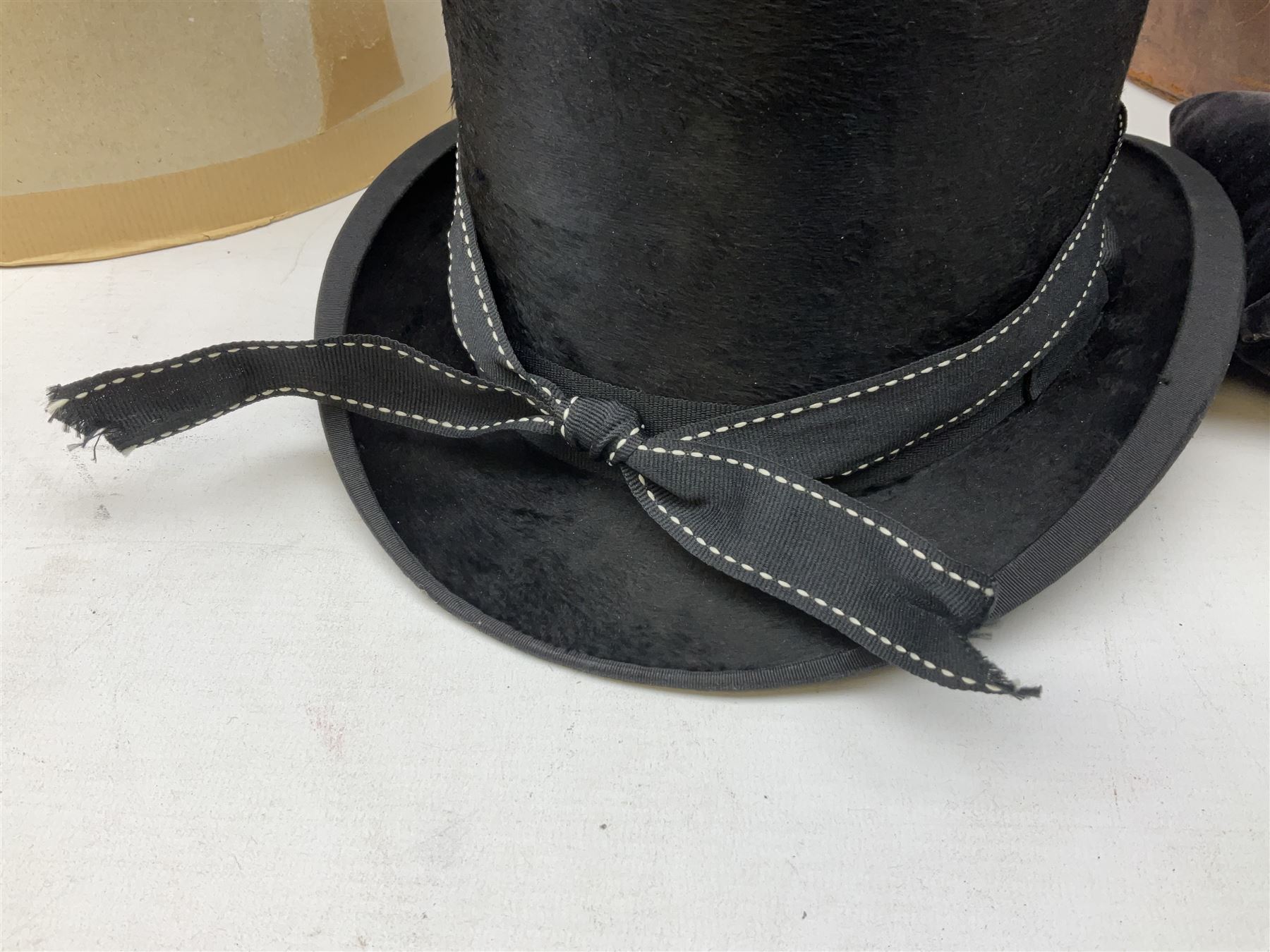 Leather hat box containing black felt top hat with 'British Manufacture' label, together with a grey top hat with 'Allens of Harrogate' label 