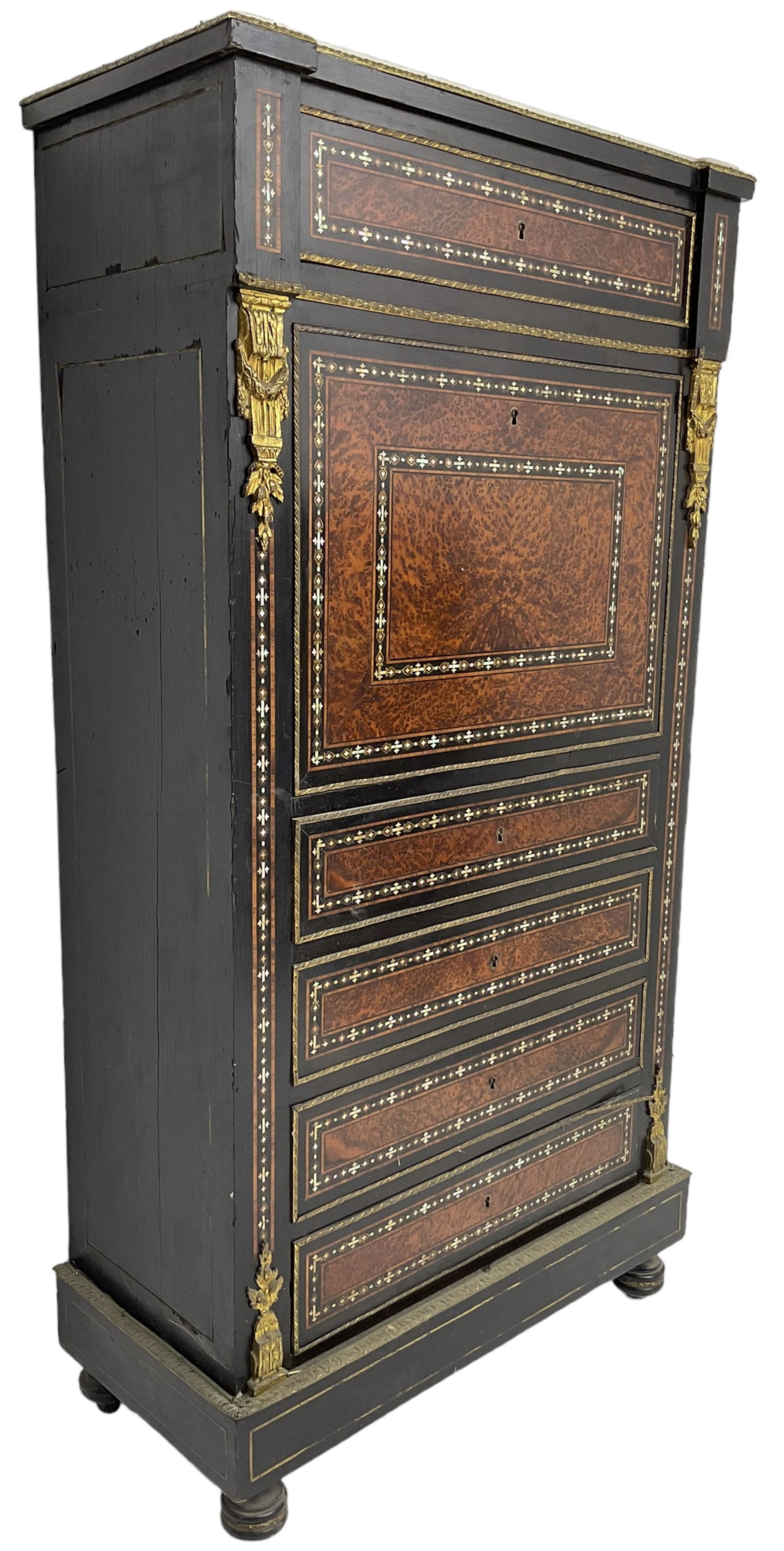 Late 19th century French ebonised and amboyna secrétaire à abattant, white marble top over frieze drawer, fall front and four further drawers, inlaid with trailing pattern in mother of pearl, mounted by cast gilt metal brackets with floral festoons, plinth base with foliate mounted edging and brass stringing, on turned feet 