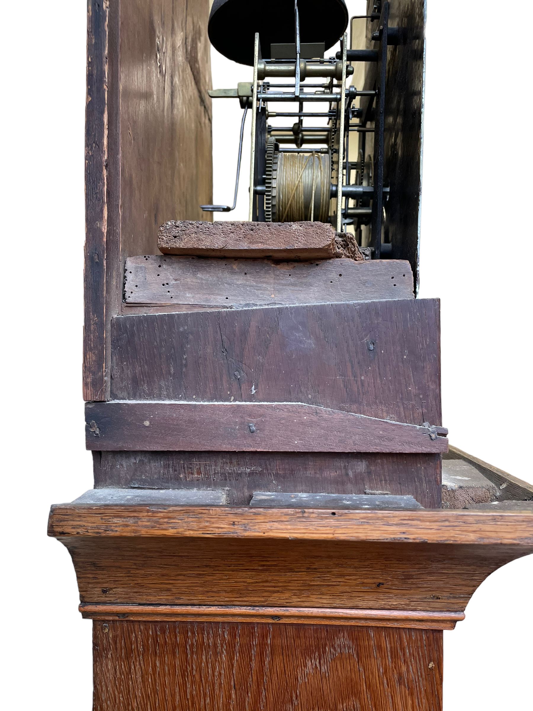 William Gostling of Diss  (Norfolk)-  Late 18th century 8-day oak longcase clock c1780-90, break arch top with scalloped cresting and three brass finials, glazed break arch hood door flanked by turned pilasters with brass capitals, trunk with a long trunk door and rounded top on a square plinth with an applied and shaped skirting, early painted Wilson of Birmingham dial with Roman numerals and five minute Arabic's, matching steel hands and second pointer, arched square ended calendar aperture with date disc behind, floral spandrels within gesso borders and a painted rocking automaton representing Mercury to the break arch, dial pinned via a false plate to a weight driven rack striking movement with a recoil anchor escapement, striking the hours on a cast bell. With pendulum weights and key. 
William Gostling (II) is recorded as working in Diss from 1774 to 1797, succeeded by widow Anne and son George . The dial of this clock is illustrated and discussed in detail in M.F. Tennants book 