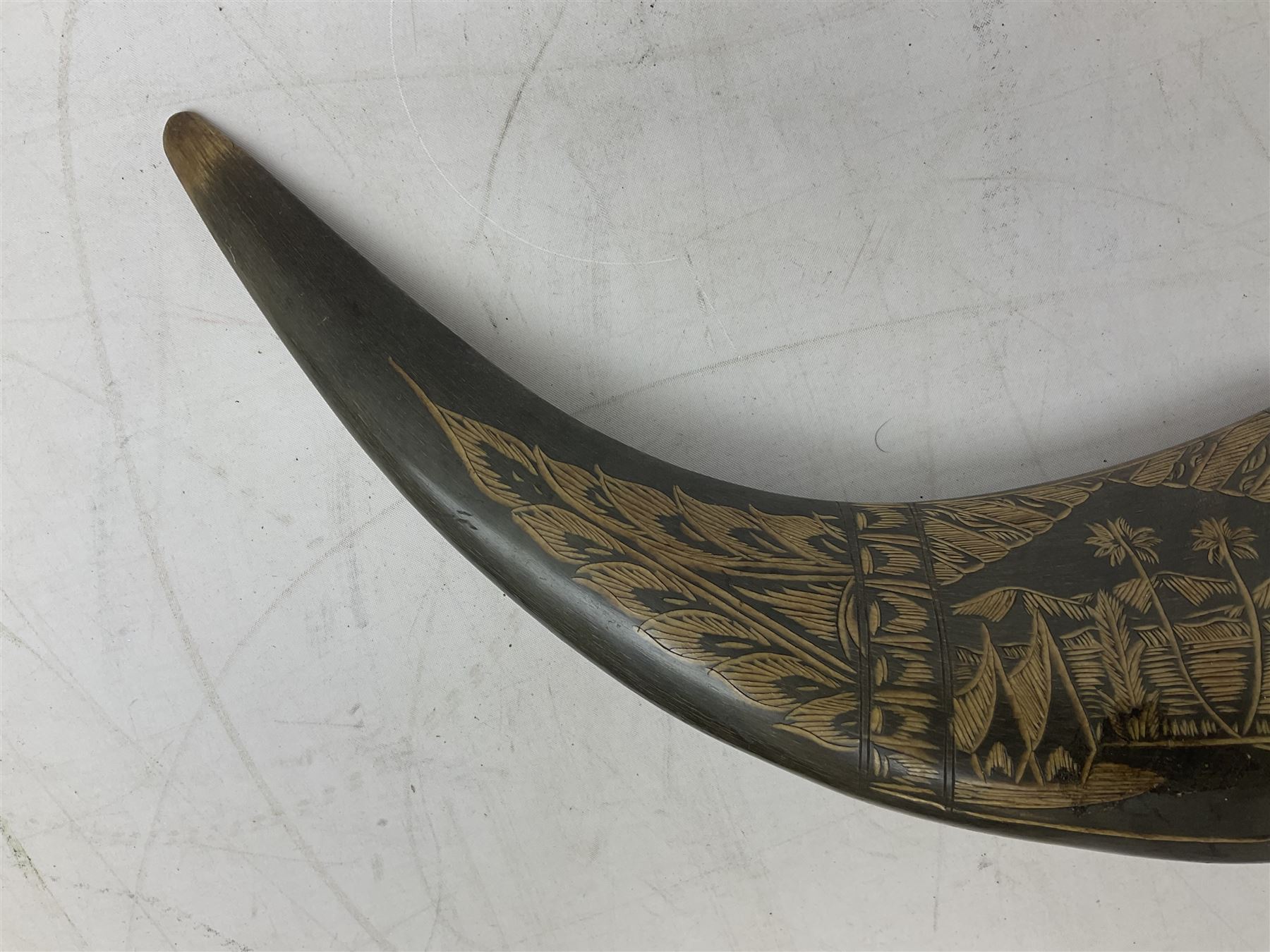 Carved water buffalo horn wall pocket, engraved with landscape scene with patterned borders with pierced foliate panel, together with a pair of horns with similar engraved decoration, L47cm