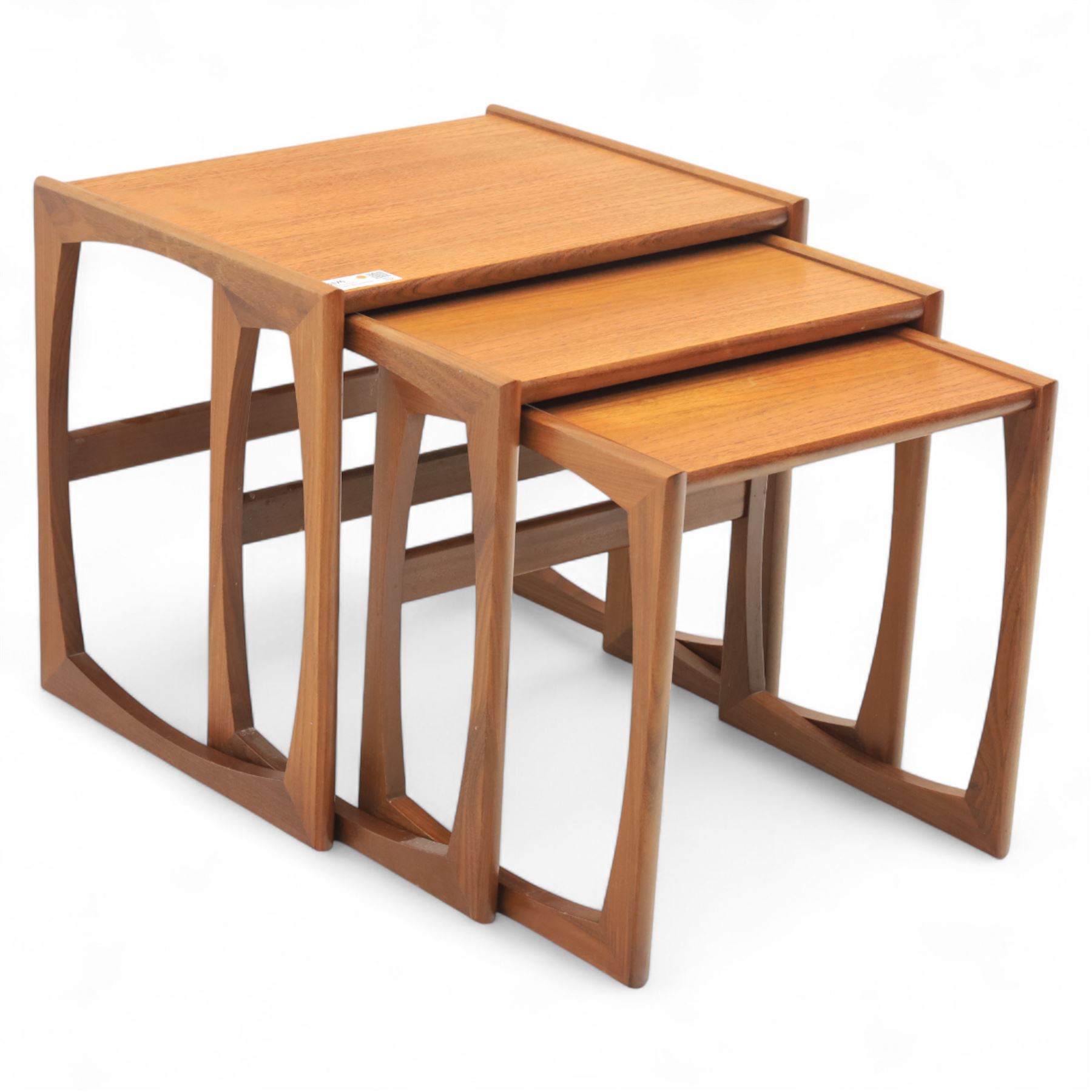 G-Plan - mid 20th century nest of three teak tables, rectangular tops with rounded edges, supported by sculptural open sided frames
