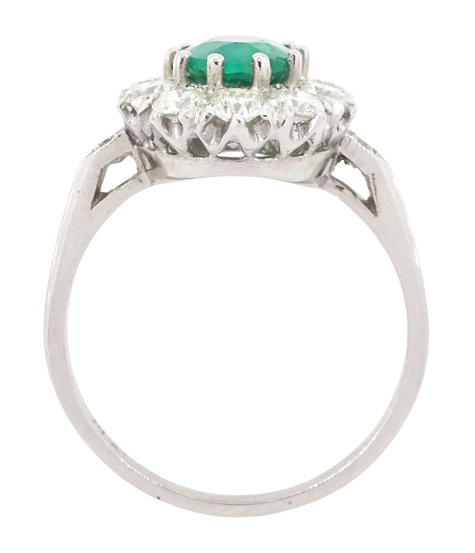Platinum emerald and diamond cluster ring, single oval cut emerald of approx 0.90 carat, surrounded by ten round brilliant cut diamonds, and milgrain set diamond shoulders, stamped Plat, total diamond weight approx 1.00 carat