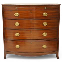 Regency period mahogany bow-front bachelor's chest, shaped top with moulded edge, fitted with brushing slide over four long graduating drawers, each with original pressed brass handle plates, raised on splayed feet 