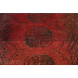 Antique Persian Bokhara red ground runner rug, repeating Gul pattern, surrounded by borders, with fringed ends