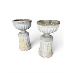 Four 20th century good quality weathered cast stone pedestal urns, circular lobed bowls with rope twist and lattice border, raised on squat base with fluted columns