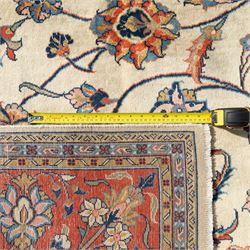 Persian Sarough carpet, ivory field with symmetrical arrangement of scrolling vines, palmettes and floral sprays in red, blue and green, enclosed by a broad red main border with repeating floral motifs, originating from the Arak region of Iran