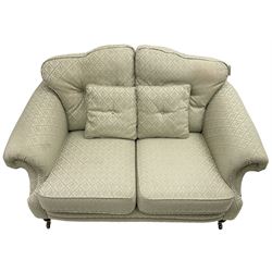 Lincoln House - two-seat sofa, shaped frame with rolled arms, upholstered in pale blue fabric with repeating foliage pattern, on turned front feet with brass cups and castors 