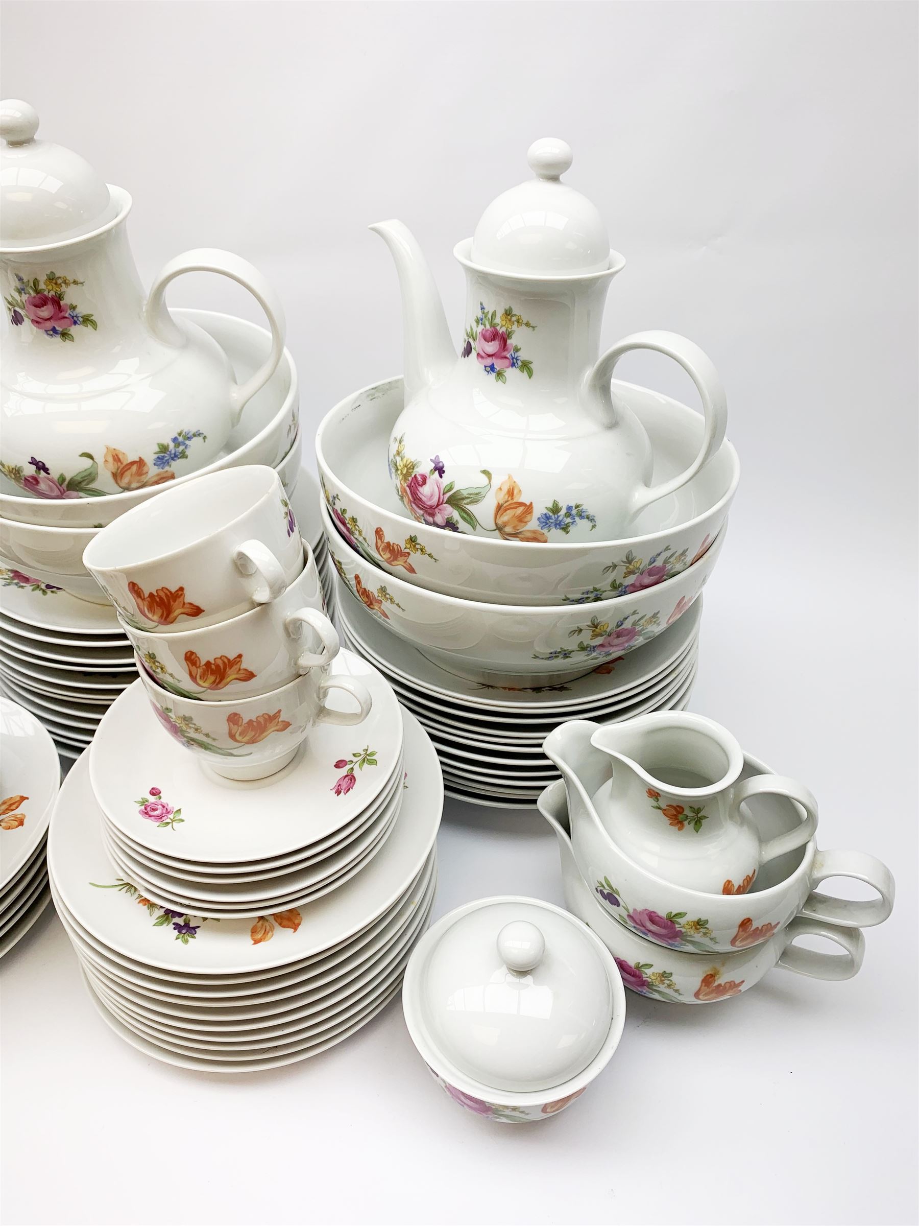 JLmenau German tea and dinner wares, comprising twelve dinner plates, seventeen side plates, twelve bowls, four large serving bowls, pair of oval serving platters, pair of smaller examples, two coffee pots, eleven teacups, twelve saucers, two milk jugs, two larger jugs, and two lidded sucriers. 