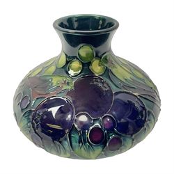 Moorcroft vase, of squat baluster form with fluted rim, decorated in the Finches pattern, in green and purple colourway upon dark blue/green ground, with printed marks beneath, H11cm