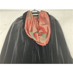Early 20th century full length black velvet cape, with ornate single hook fastening and hood, with colour shift red, green and brown silk lining