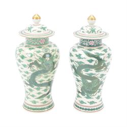 Pair of Chinese famille verte vases and covers, each of baluster form, decorated with drag...