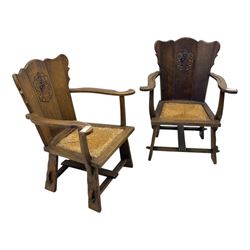 Pair of Arts and Crafts oak armchairs each with shaped backrest centred by polychrome painted crest, rush seat over straight square legs united by shaped central stretcher