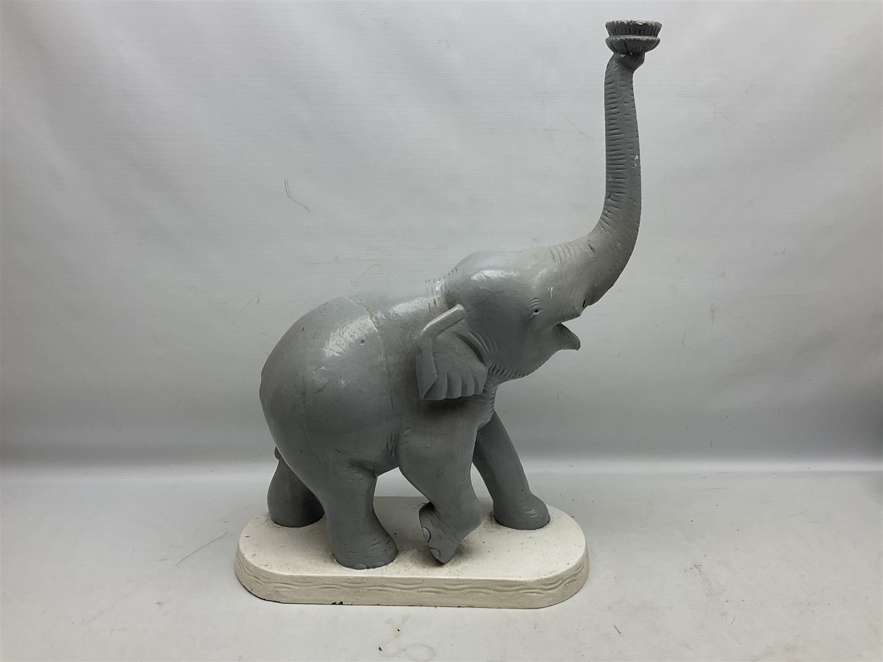 Composite figure of an elephant, painted grey, upon white base, L45cm H65cm