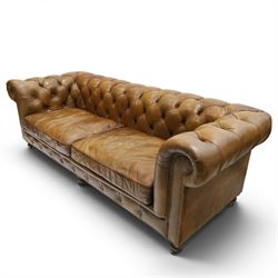 Timothy Oulton for HALO - Three seater brown leather chesterfield sofa, with button back and arms, with two loose cushions, raised on a dark stained supports terminating in castors 