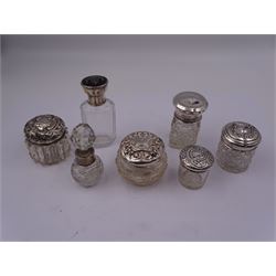 Group of dressing table jars and bottles, to include a 1920's bottle, the clear glass facet cut body with screw threaded silver cover with inset tortoiseshell panel detailed with silver swag, hallmarked E S Barnsley & Co, Birmingham 1921, H10cm, a Victorian scent bottle, the spherical cut glass body with silver collar and later cut glass stopper, a late Victorian dressing table jar, and two Edwardian examples, each with cut glass bodies and embossed covers, etc., various hallmarks, (7)