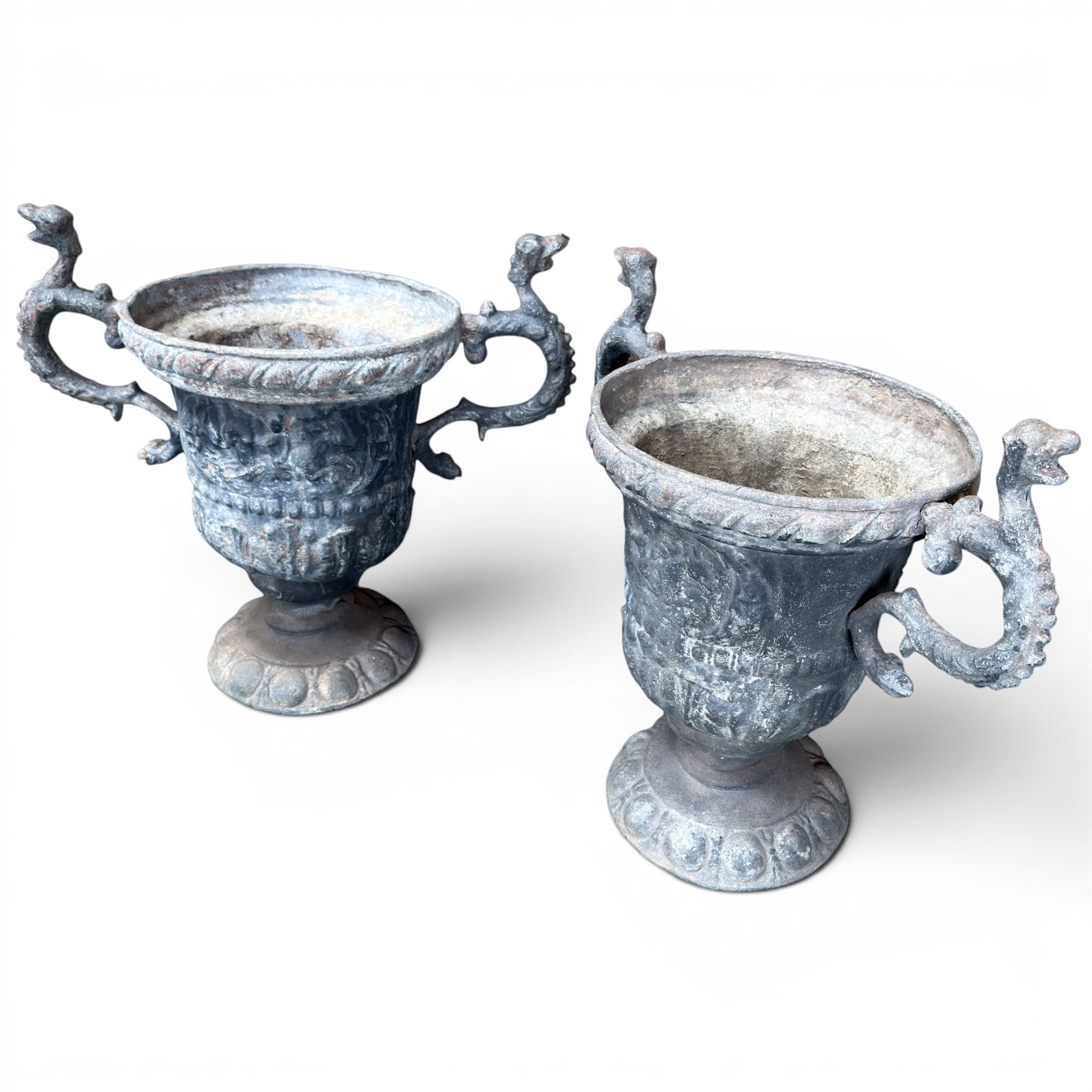 Impressive pair of early highly decorative lead garden urns, griffin handles with ornate decoration depicting cherubs and laurel wreath