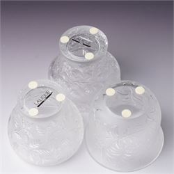 Three Lalique frosted glass tea light holders, decorated with the coriander and basil patterns, and another with trailing leaves, marked Lalique France to base, H7.5cm