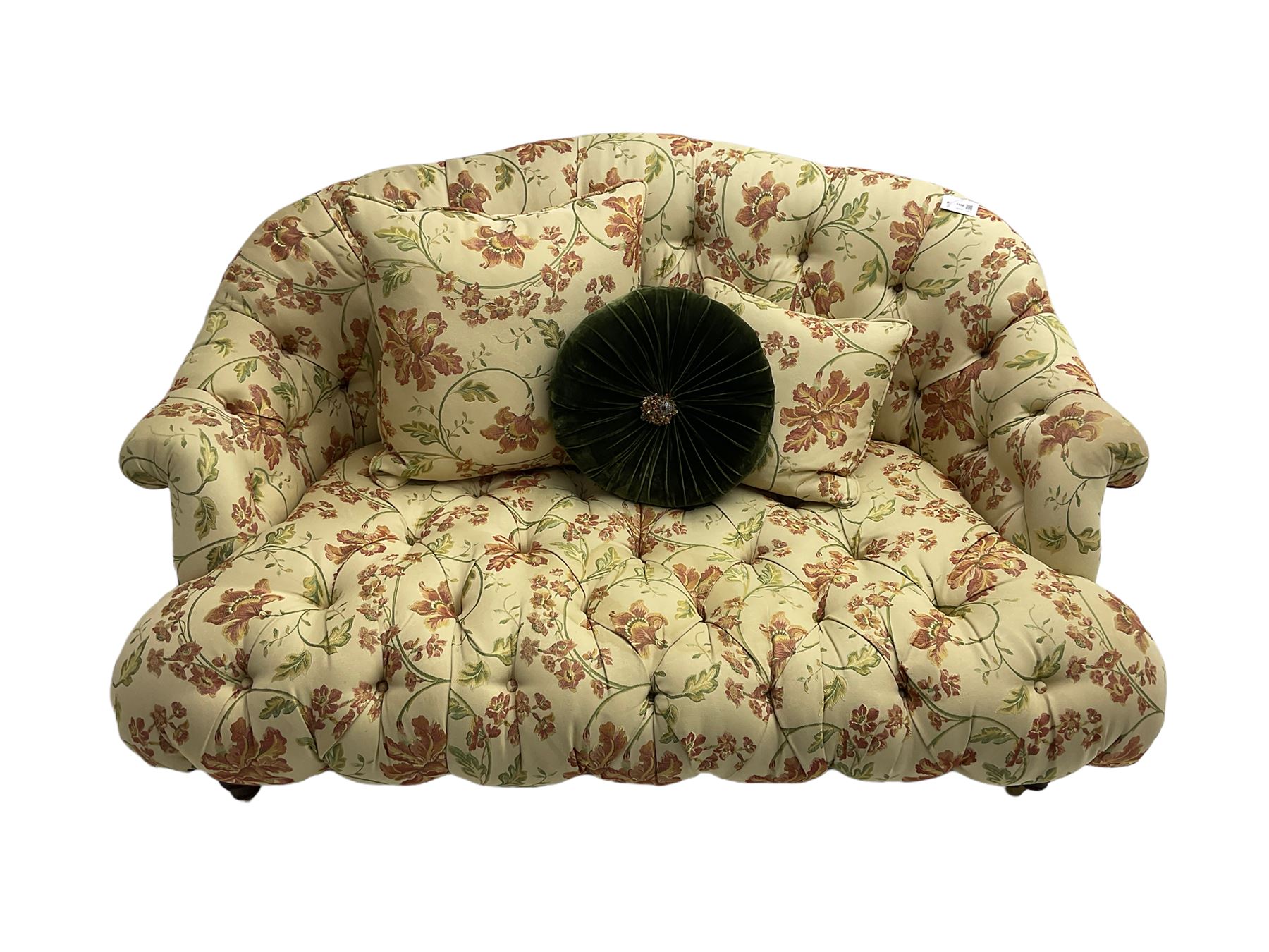 Victorian style two seat sofa, upholstered in beige ground floral floral pattern fabric, with scatter cushions, turned feet with brass castors