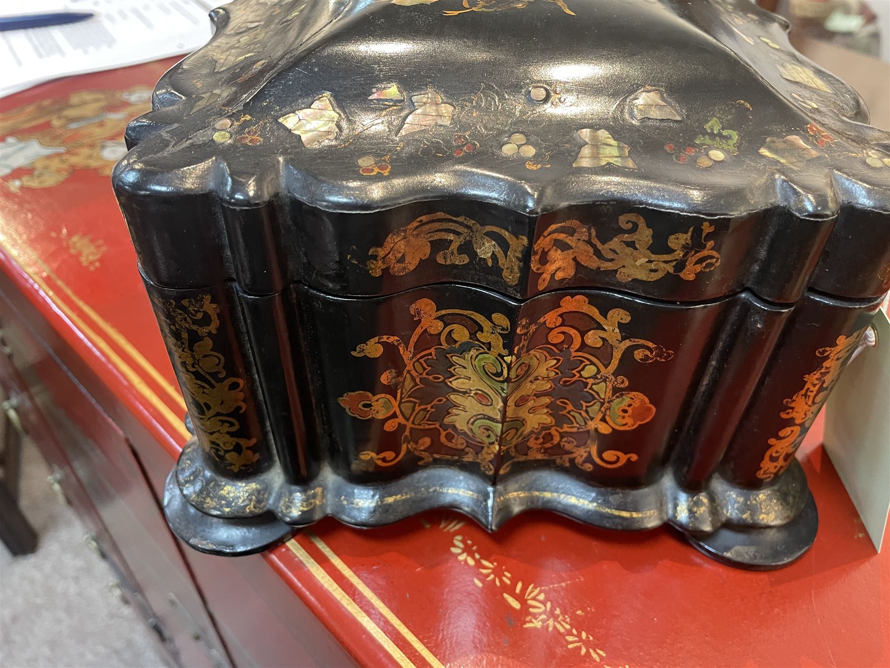 Victorian black lacquered papier-mâché sewing box, of rectangular form with shaped sides, the slightly domed top with inlaid mother of pearl and abalone decoration, the sides with gilt and polychrome painted scrollwork, the hinged cover opening to reveal a fitted interior with lift out tray, H14cm