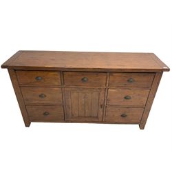 Stained pine rustic sideboard, rectangular top over seven drawers and single panelled cupboard, fitted with shell handles