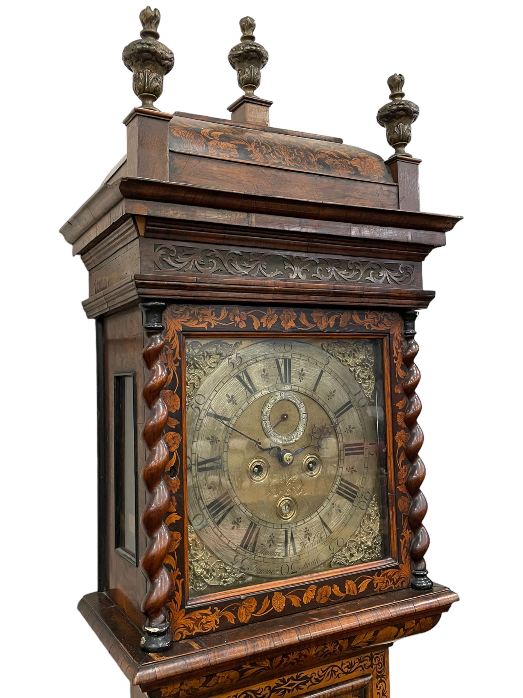 William & Mary floral marquetry 8-day longcase clock c 1700, later mid-18th century four pillar rack striking movement with a square brass dial and subsidiary seconds dial, ringed winding holes and calendar aperture to the matted dial centre, with London cherub head cast spandrels and (later) fretted steel hands, silvered Roman numeral chapter ring with stylised fleur di Lis half hour makers, narrow Arabic five-minutes, minute track and inner quarter hour track, signed Thomas Horlock, Hammersmith, 
case with box upstand to the domed floral marquetry decorated caddy with three brass flame finials, above a moulded cornice and fretwork frieze,  inlaid hood door with attached barley twist pillars to the front above an inlaid convex moulding, full length D moulded trunk door with a circular lenticle inlaid with floral and foliage panels inhabited with birds, on a conforming marquetry plinth with applied double skirting. Thomas Horlock is recorded as a Whitesmith & Clockmaker of Hammersmith, Middlesex.
A copy of Thomas Horlock's will dated the 15th June 1757 is held at The National  Archives Kew.