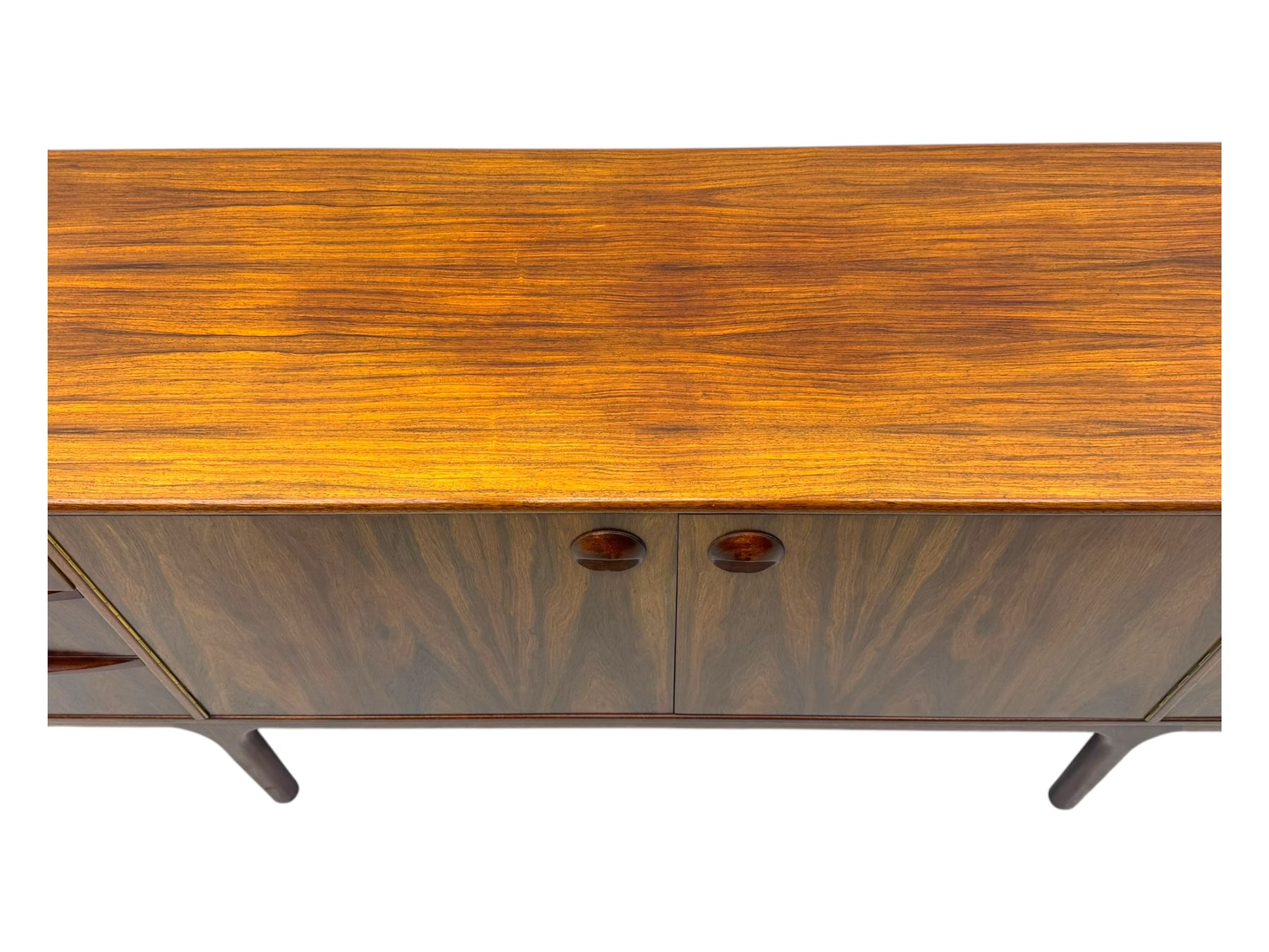 Tom Robertson for McIntosh of Kirkcaldy - mid-20th century 'Dunfermline' sideboard, the central twin cupboard doors flanked by bank of three drawers to one side and a fall front drinks cabinet to the other, raised on tapered supports