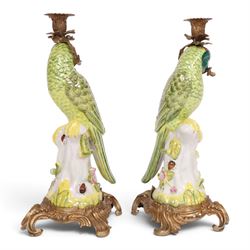 Pair of candlesticks, modelled as green parrot upon a flowering branch, upon four gilt acanthus leaf feet, H36cm