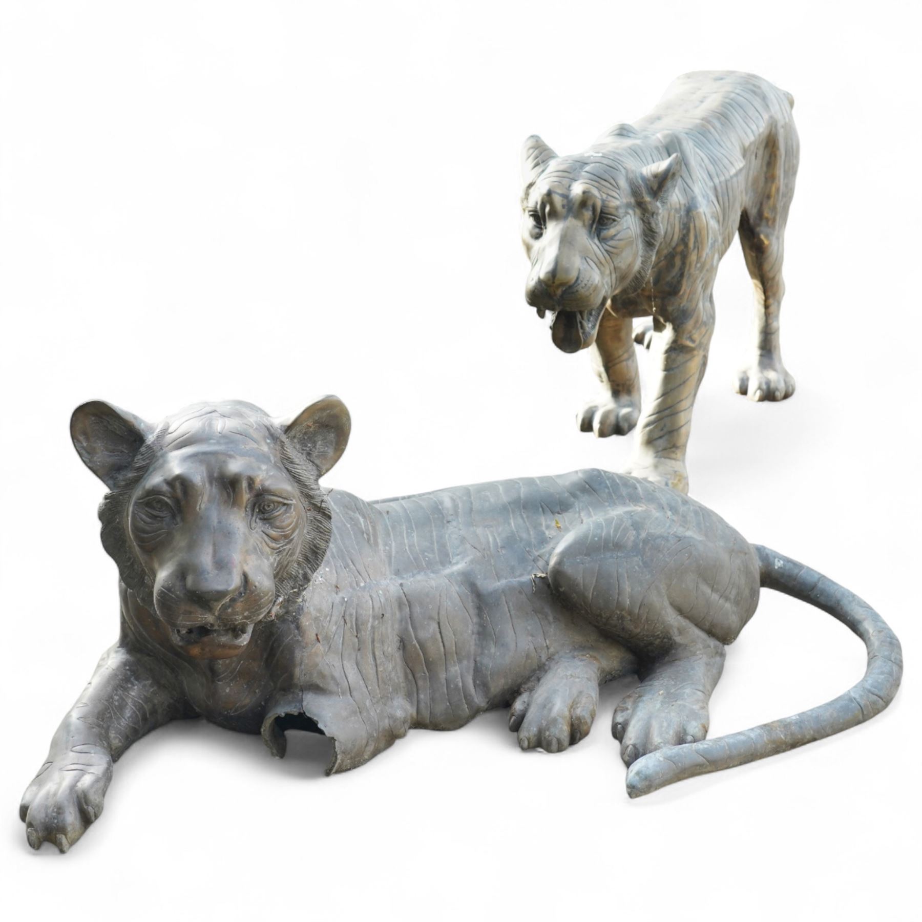 Pair of Chinese cast bronze tiger figures, one in a seated resting pose and the other advancing with open mouth, both with incised striping and aged bronze patina
Seated tiger (H 54cm, W 63cm, L 129cm)
Stood tiger (H 76cm, W 40cm, L 176cm) 