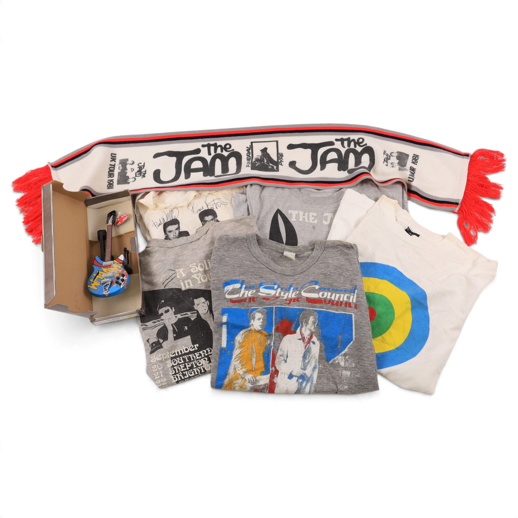 Five 1980s The Jam/Paul Weller/The Style Council tour/band t-shirts, including Cafe Bleu, The Paul Weller Movement, Dig The New Breed, A Solid Bond in Your Heart and Beat Surrender Tour 1982, together with a 1981 The Jam tour scarf and a Baby Axe Company miniature model of Paul Weller's Rickenbacker guitar
