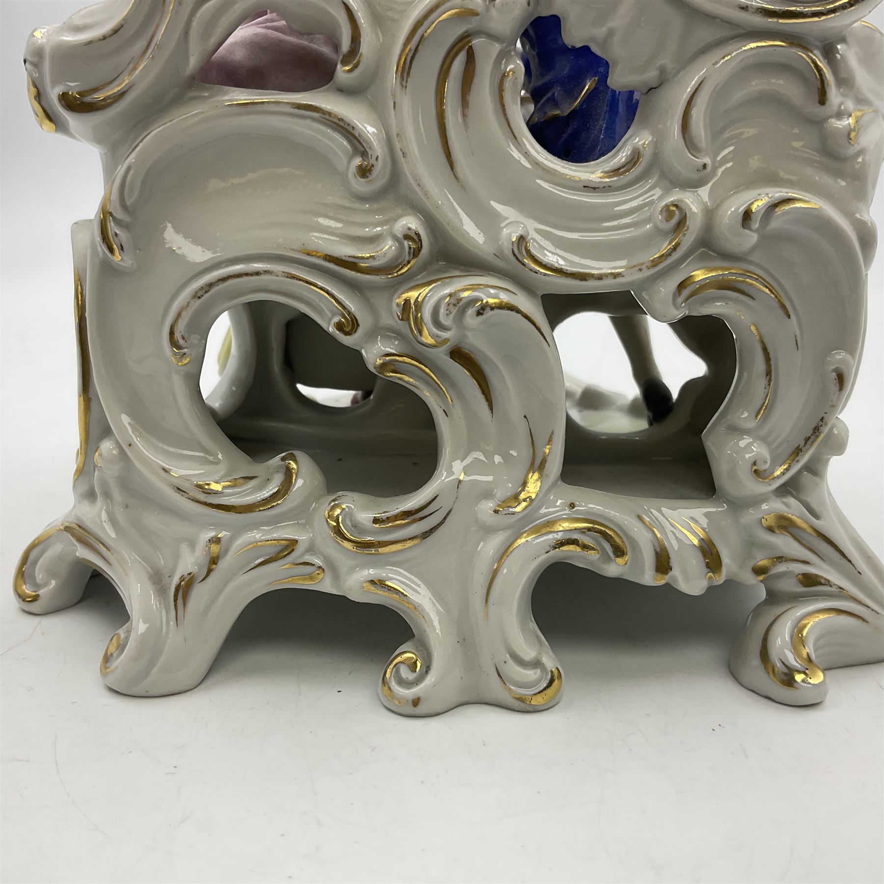 Figure group, probably Volkstedt, modelled as a courting couple seated before a table, the ornate bench and table conforming with and leading from the gilt heightened scrolling base, with blue painted mark beneath, H14.5cm
