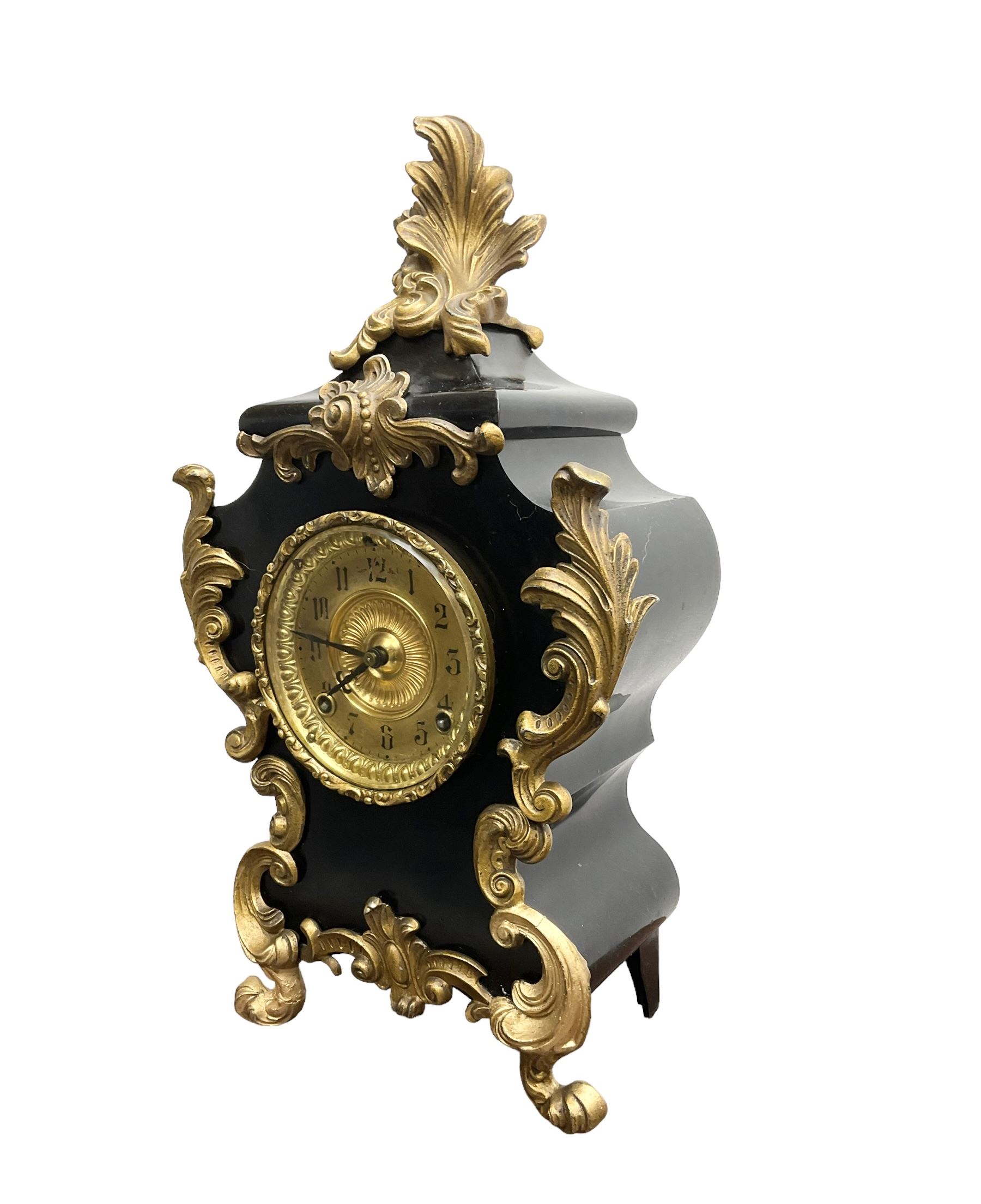 Ansonia - American late 19th century steel cased 8-day mantle clock in a Rococo case with decorative brass mounts, brass dial with Arabic numerals, steel hands and a repousse dial centre, twin train striking movement sounding the hours and half hours on a gong. with pendulum and key.