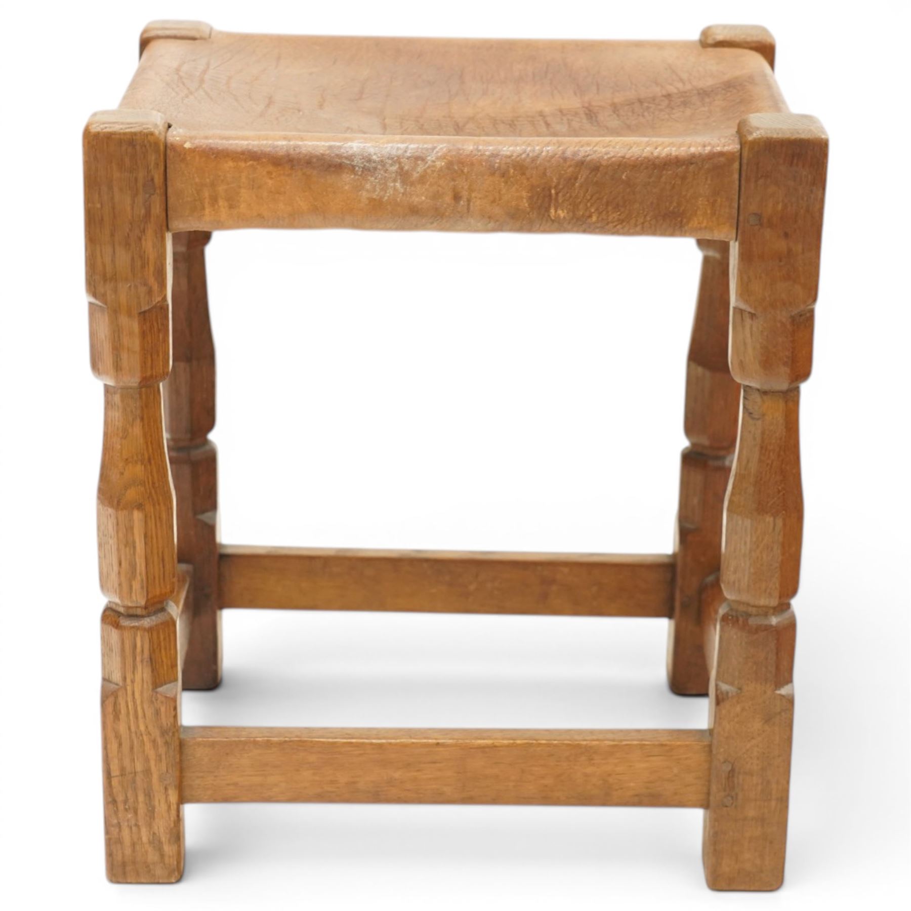Mouseman - 1950s dark oak dressing table stool, the rectangular top with tan leather seat, raised on octagonal supports united by box stretcher, carved with mouse signature, by the workshop of Robert Thompson of Kilburn