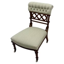 Late Victorian upholstered armchair, with high camel back and deep seat, padded arms and backrest in crimson and cream damask-style fabric, raised on turned ebonised front supports with ceramic castors (H88cm, W65cm, D 60m); and an Edwardian bedroom chair with button upholstered rail back (H72cm, D64cm, W53cm) (2)