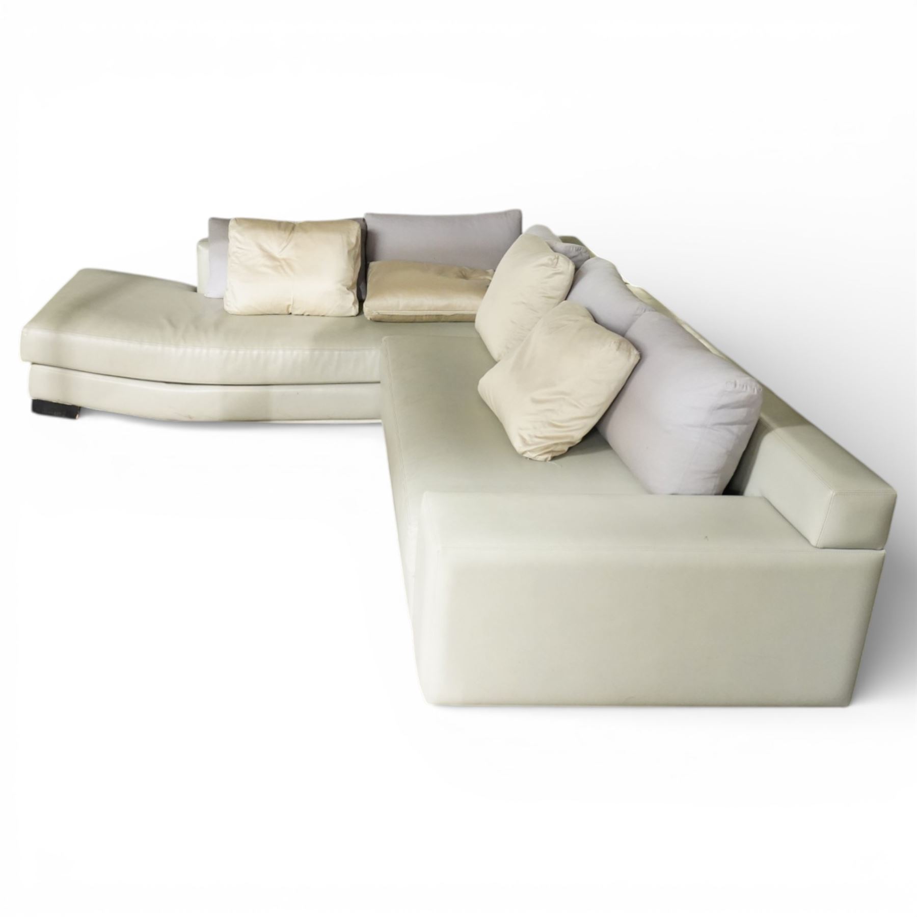 Christian Liaigre (1943-2020) - 'Arpege' handmade L-shaped sectional sofa, upholstered in neutral leather, with broad squared arms, deep seat cushions, angled chaise section, loose back cushions, raised on block feet