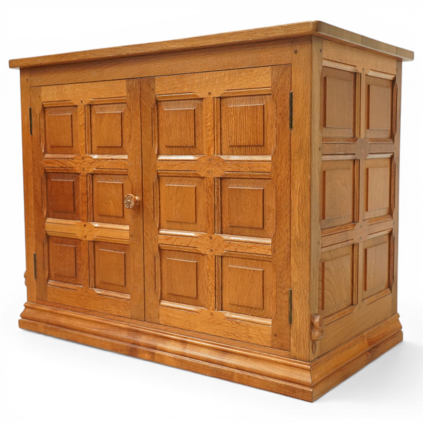  Beaverman - oak media cabinet, rectangular top with interictally carved panels to the side and front doors, twin doors with Yorkshire Rose carved wooden knob, enclosing a staggered shelf arrangement above two drawers, raised on a moulded plinth base, with carved beaver signature, by Colin Almack of Sutton near Thirsk