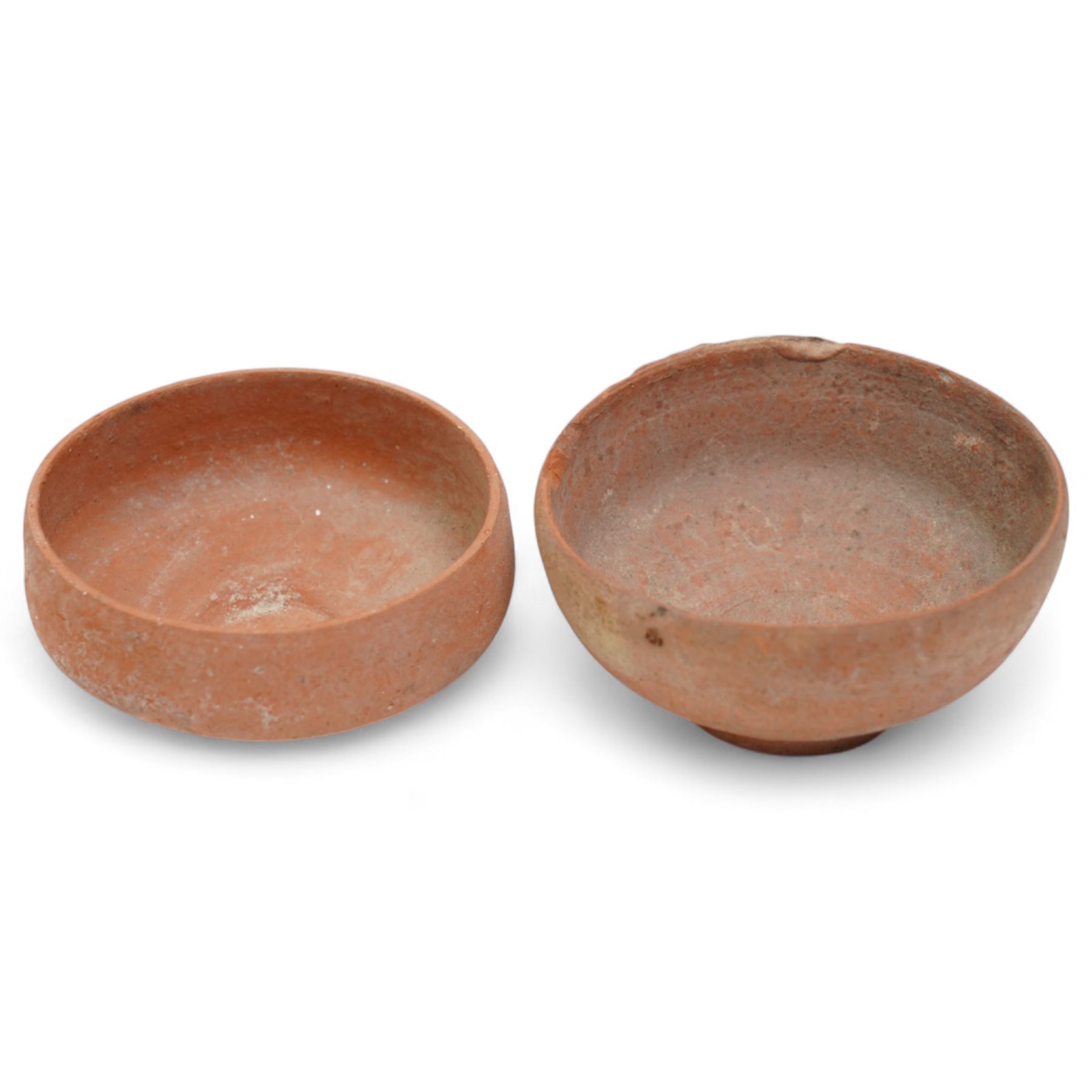 A group of eight ancient terracotta vessels - Near East and Eastern Mediterranean c.2nd millennium BC-1st century AD, comprising a Nabataean red terracotta ‘eggshell’ bowl (c.1st century BC-1st century AD) finely wheel-made with a thin-walled hemispherical form and pale red slip; a Near Eastern black-burnished spouted vessel (c.1800-1600 BC) of globular form with single handle and short spout; large Roman or Late Iron Age single-handled jug (c.1st century BC-1st century AD) wheel-made with a wide neck and ovoid body; together with five further vessels including shallow dishes, squat jars and a ribbed bottle, likely of Middle Bronze Age Levantine and Roman provincial types.
Provenance: By the vendor’s repute, acquired/collected in the Middle East (Dead Sea area/Syria) in the 1960s