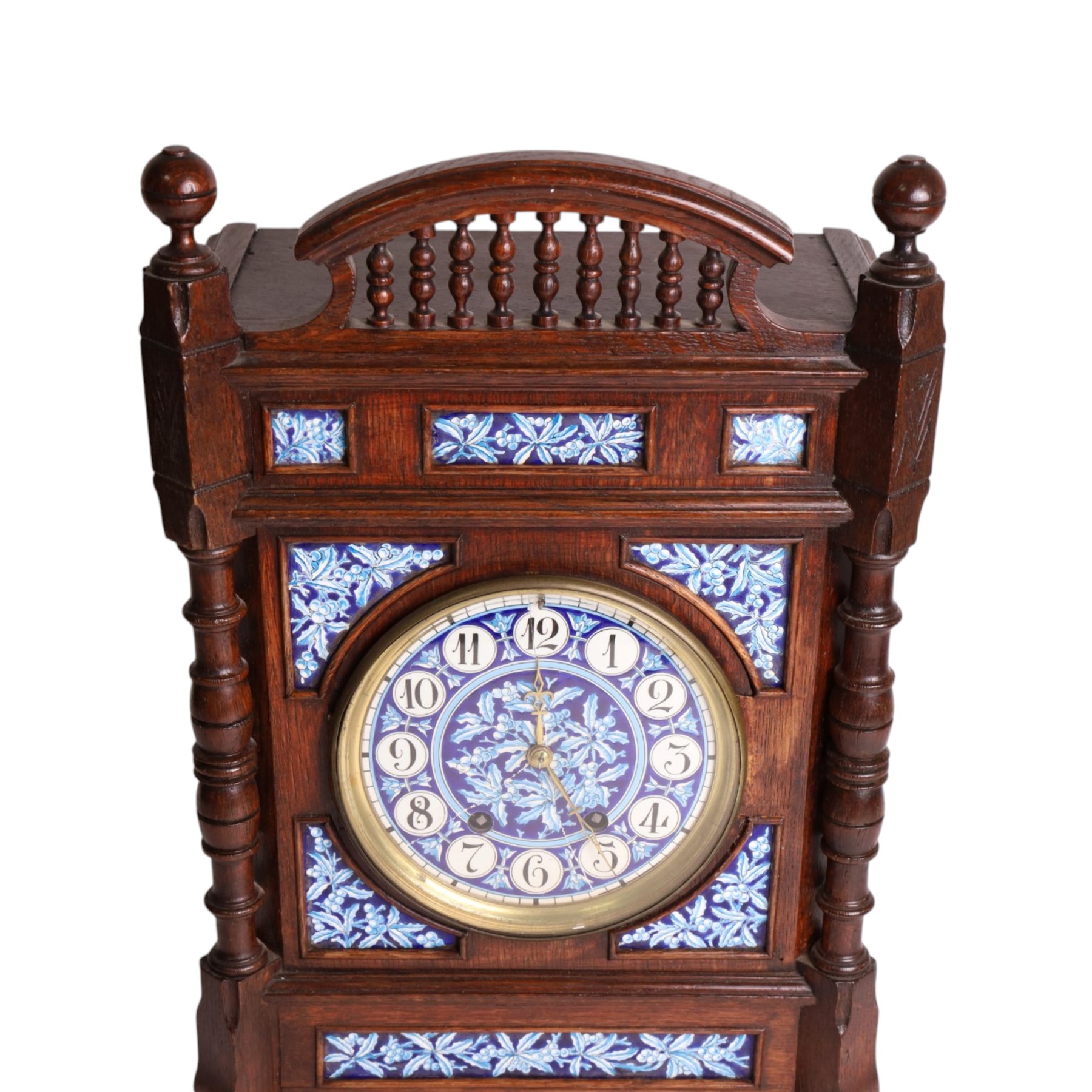 Aesthetic Movement mantel clock, in an oak case with turned detail and ceramic panels decorated with blue and white holly with berries, H48cm