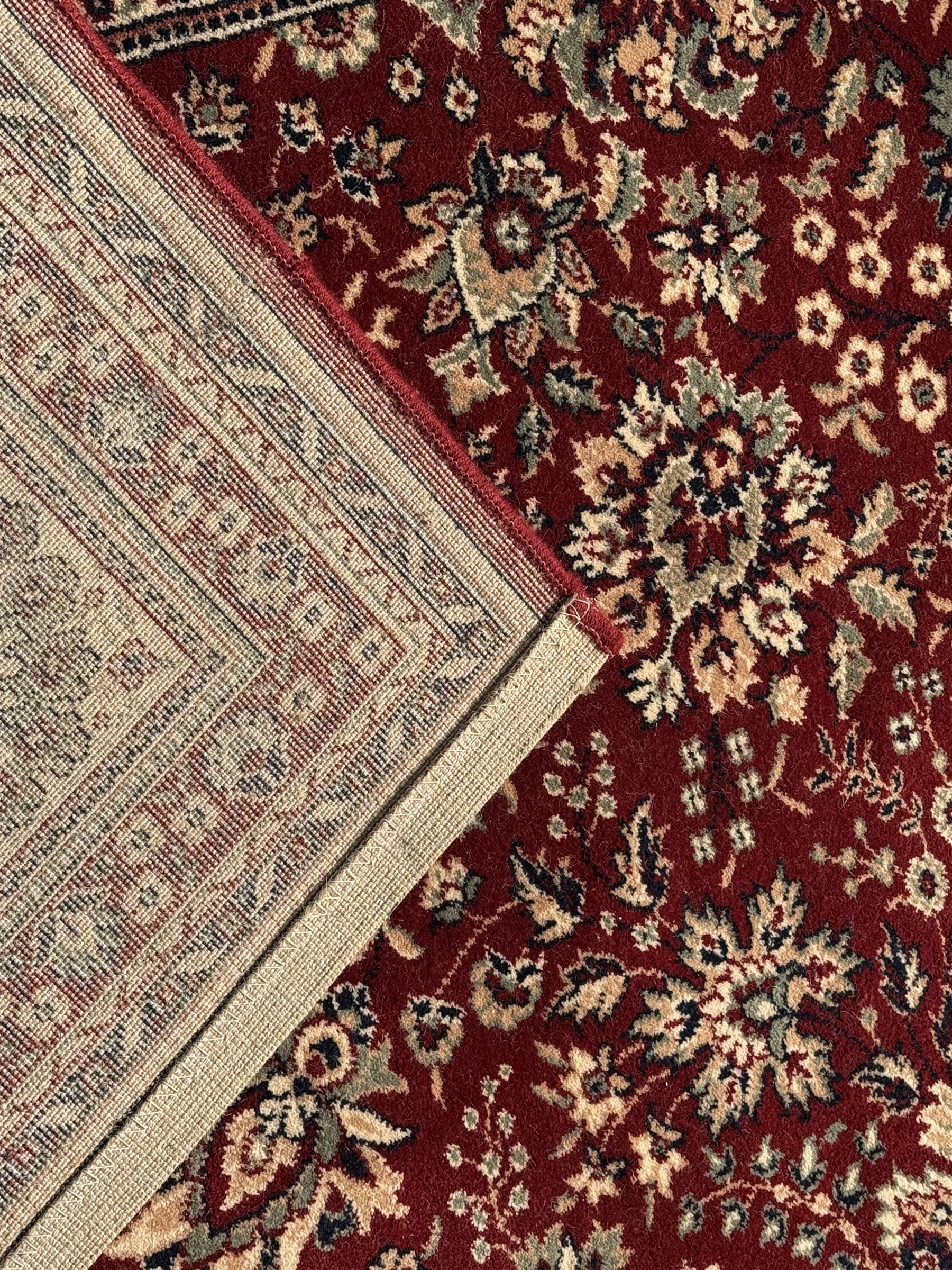 Royal Kashmir worsted wool modern Persian design area rug, with crimson field and stylised rosette patterning throughout, surrounded by wide multi-band border incorporating cartouche and lotus flower motifs