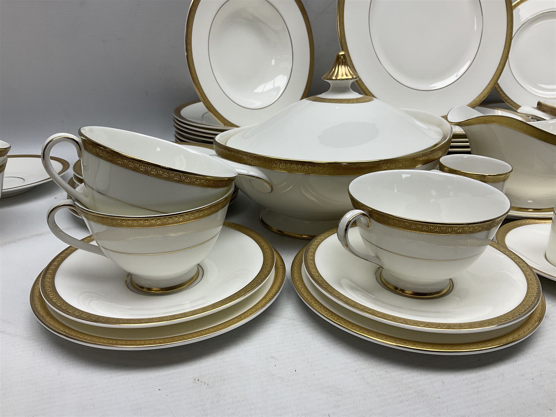 Royal Doulton Royal Gold pattern tea and dinner service for eight, comprising dinner plates, side plates, tea plates, soup bowls, sauce boat and saucer, dessert bowls, coffee cans and saucers, teacups and saucers and two lidded tureens