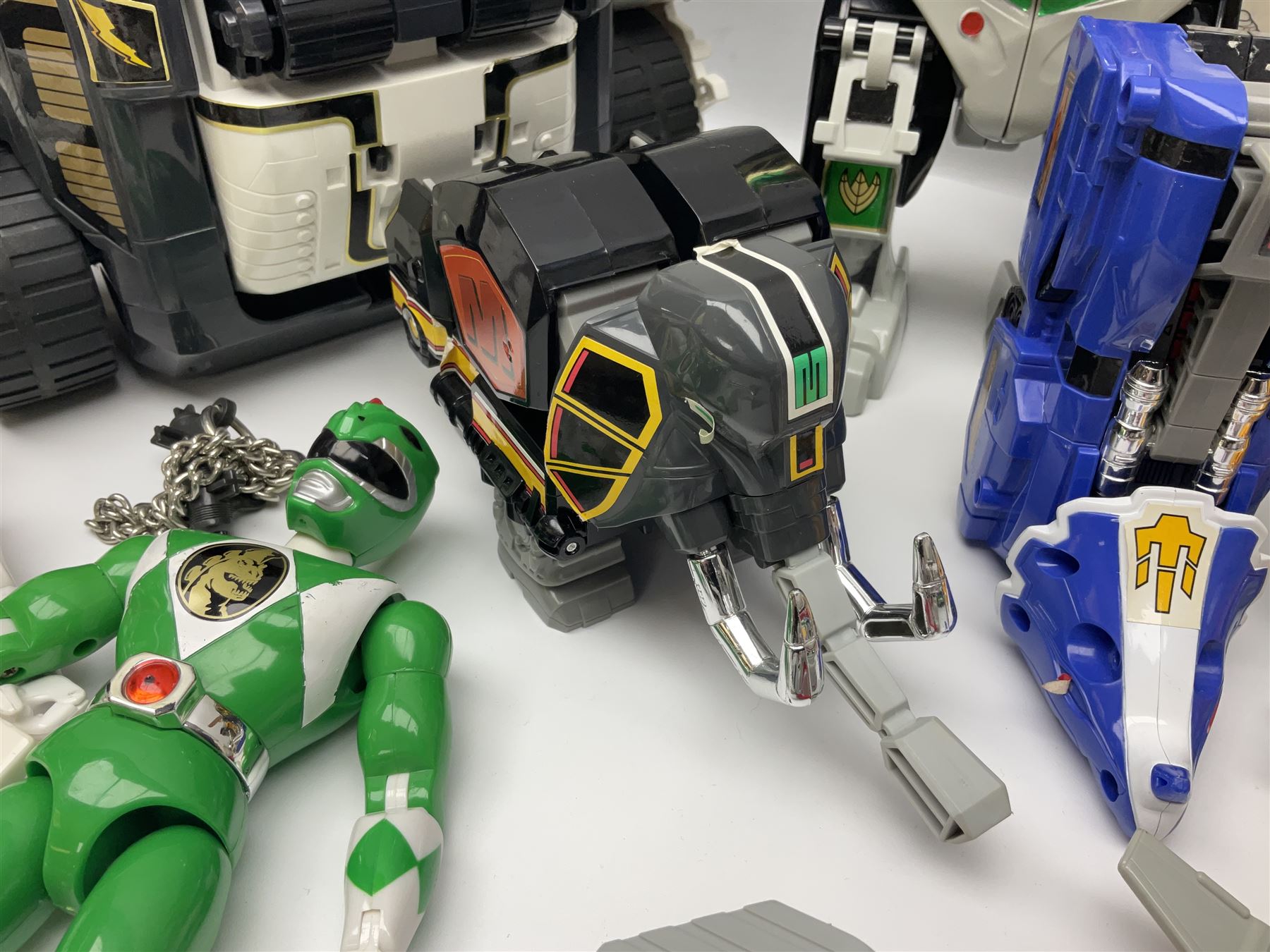 Collection of early 90s Mighty Morphin’ Power Rangers Zords, figures and accessories. Titanus the Carrier Zord, marked Bandai 1991; Green Dragonzord, incomplete; 1994 White Tigerzord with original instruction manual; 1993 Triceratops Dinozord, Mastodon Dinozord and Sabertooth Tiger Dinozord, Pterodactyl Dinozord, missing guns; with 1993 Power Morpher and original Power Coins, with further related figures, accessories and weapons