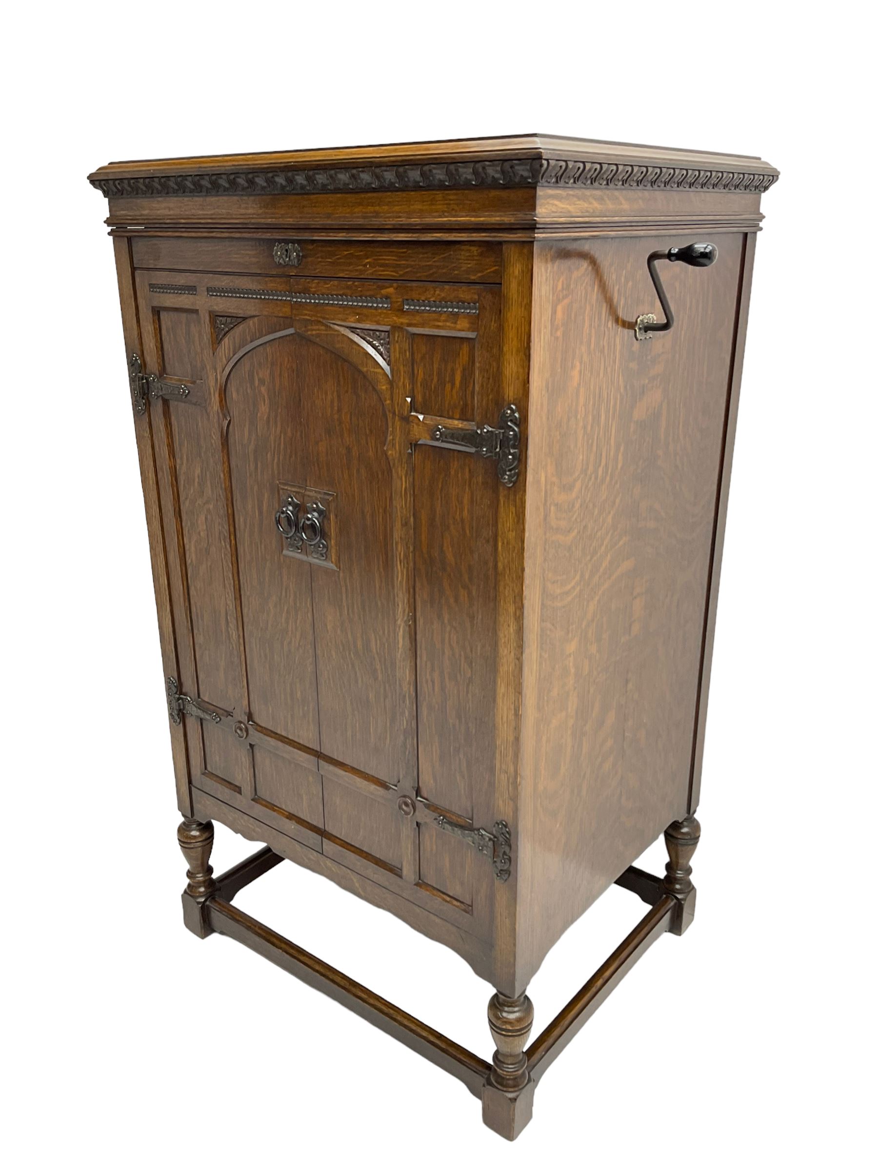 Early 20th century ‘HMV' 202 cabinet gramophone, oak cased, moulded top with foliate carved moulding hinges to reveal gramophone, two doors enclosing horn, on turned supports joined by moulded stretcher rails