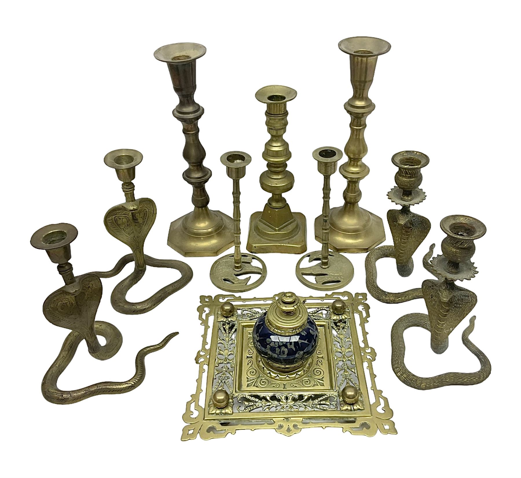 Brass inkstand, of square form, pierced, inset with blue and white ceramic inkwell to centre, together with a collation of brass candlesticks 