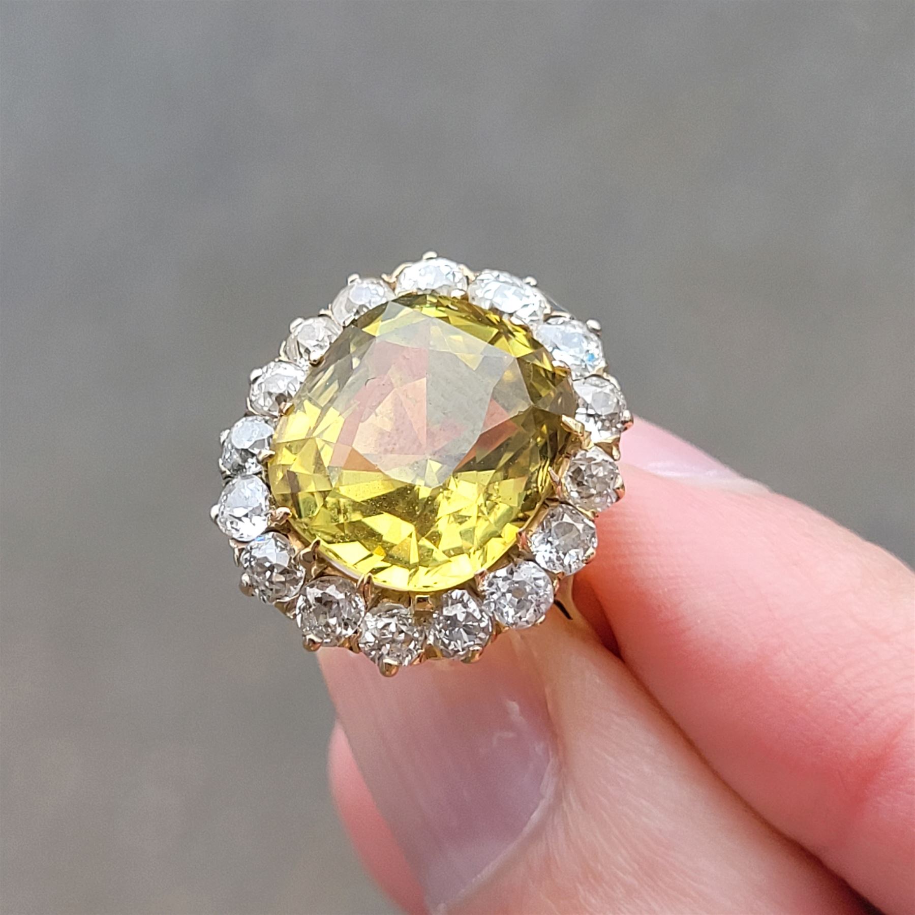 Early 20th century gold chrysoberyl and diamond cluster ring, single cushion cut yellow / green chrysoberyl of approx 8.00 carat, surrounded by sixteen old cut diamonds, stamped 18ct, total diamond weight approx 1.10 carat